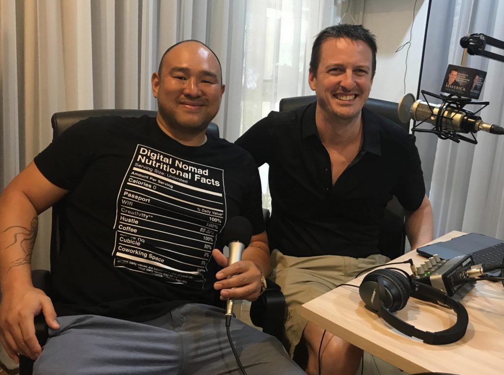 two men recording a podcast, smiling at the camera