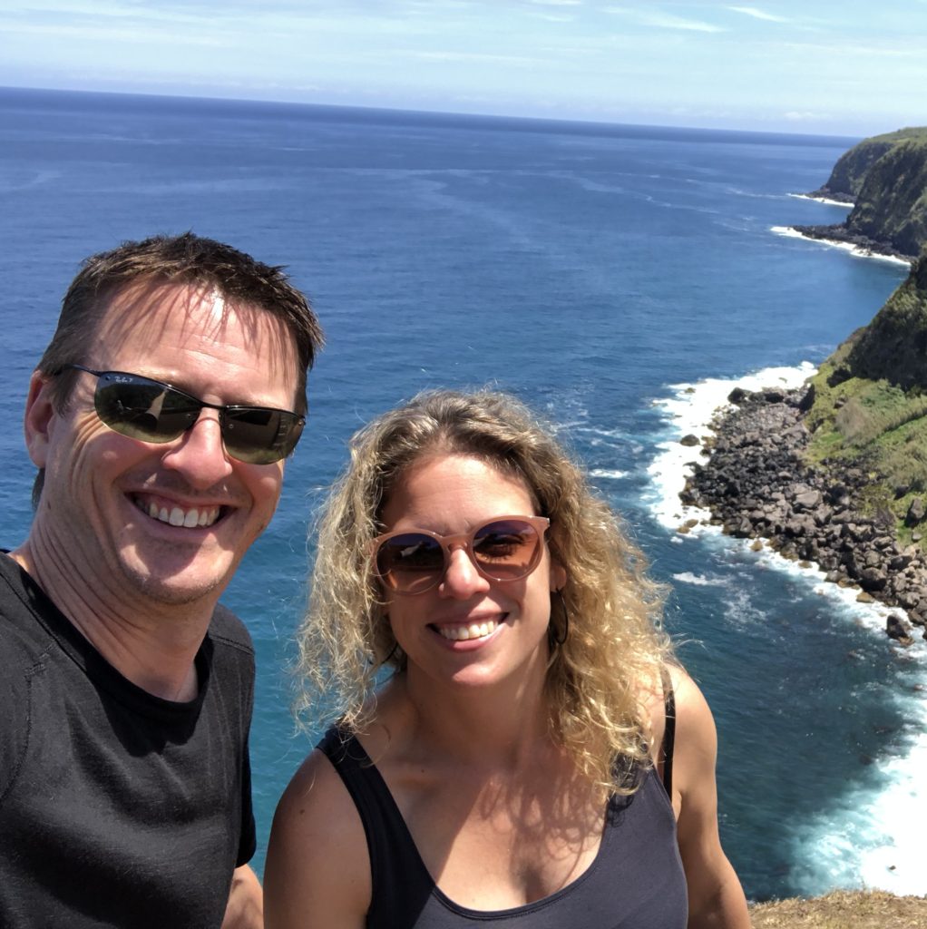 a man and a woman with an ocean view background