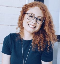 woman with curly red hair sitting on a couch