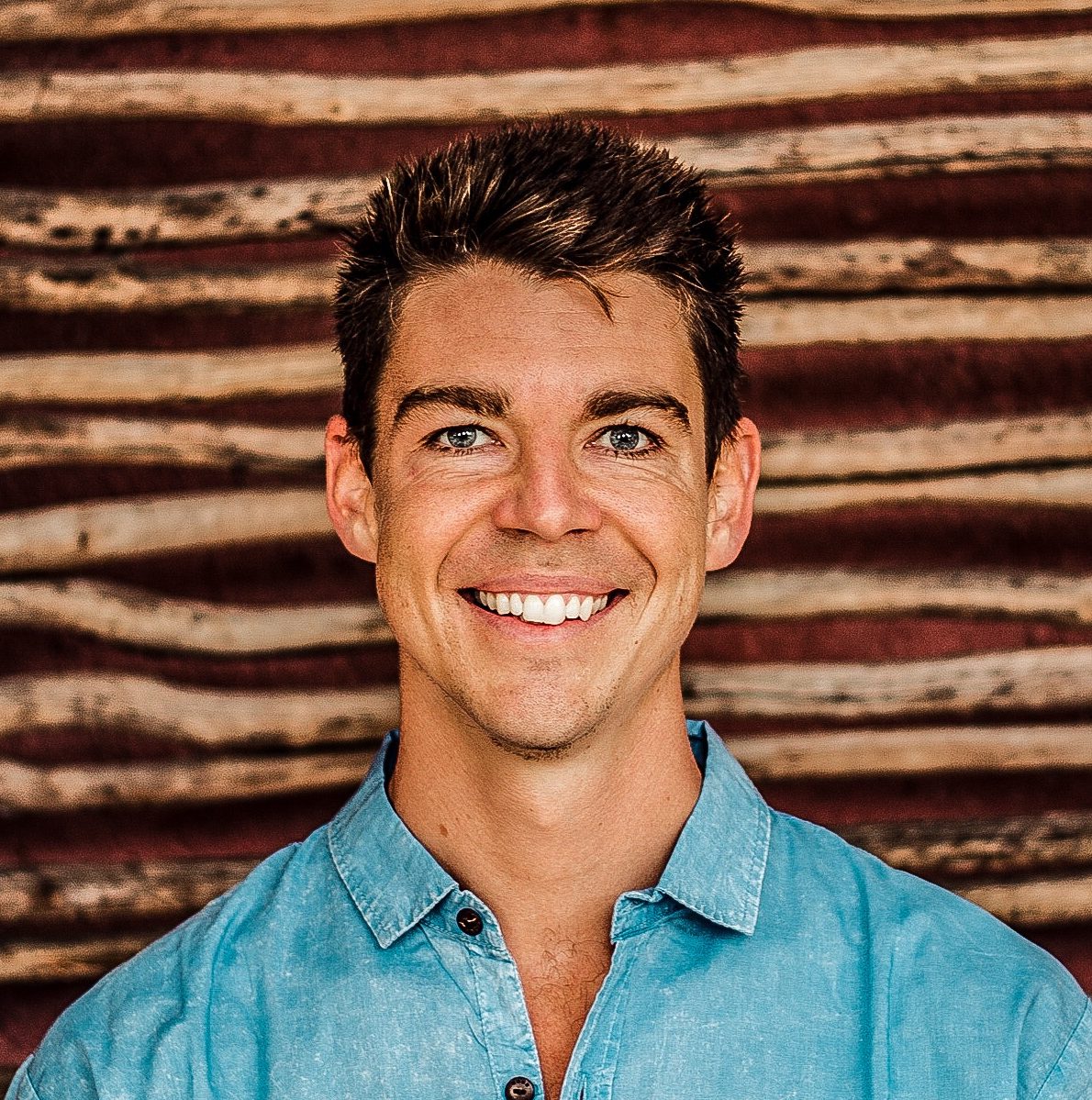 man in a denim shirt smiling