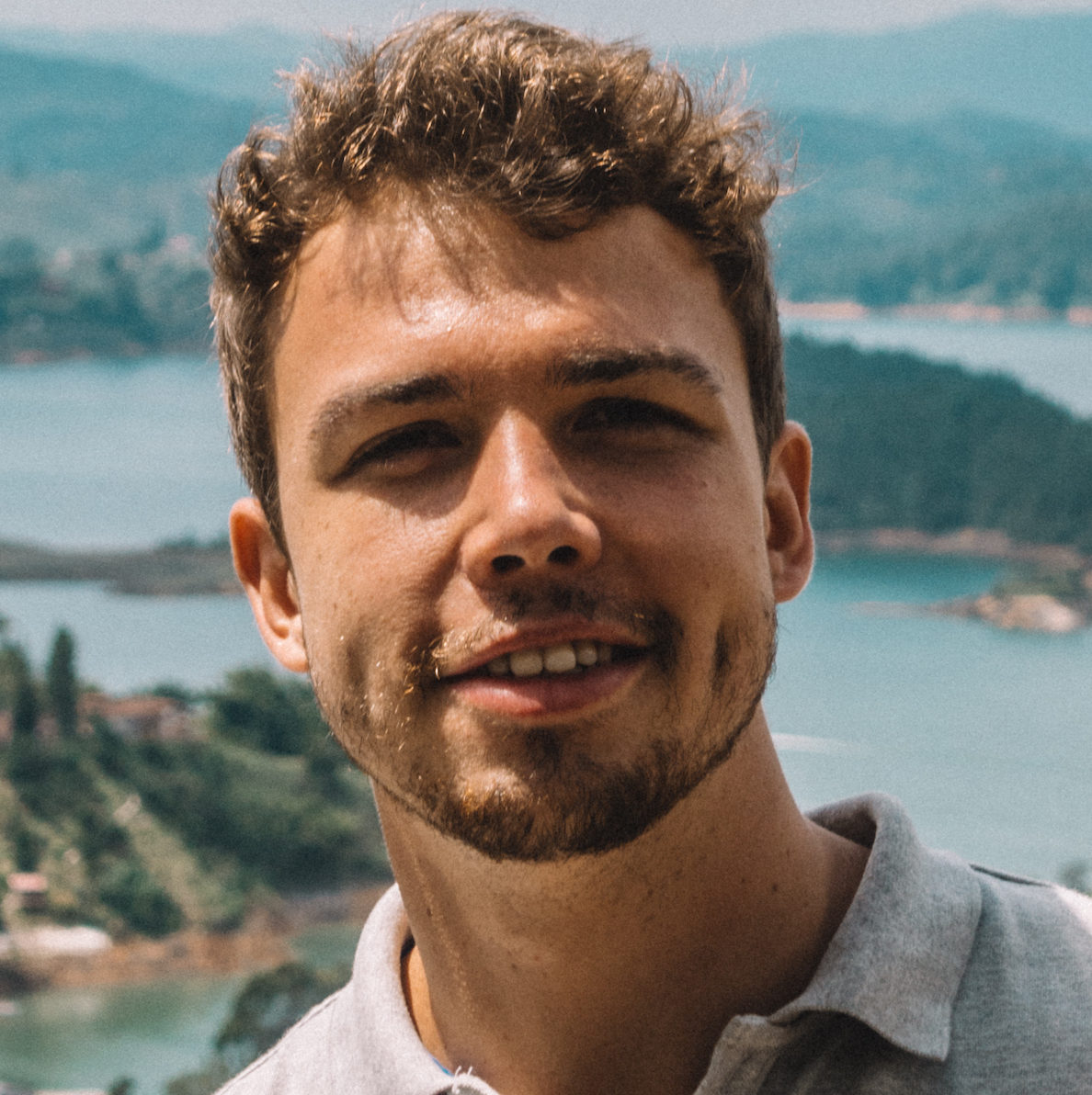 headshot of a man with a scenic background