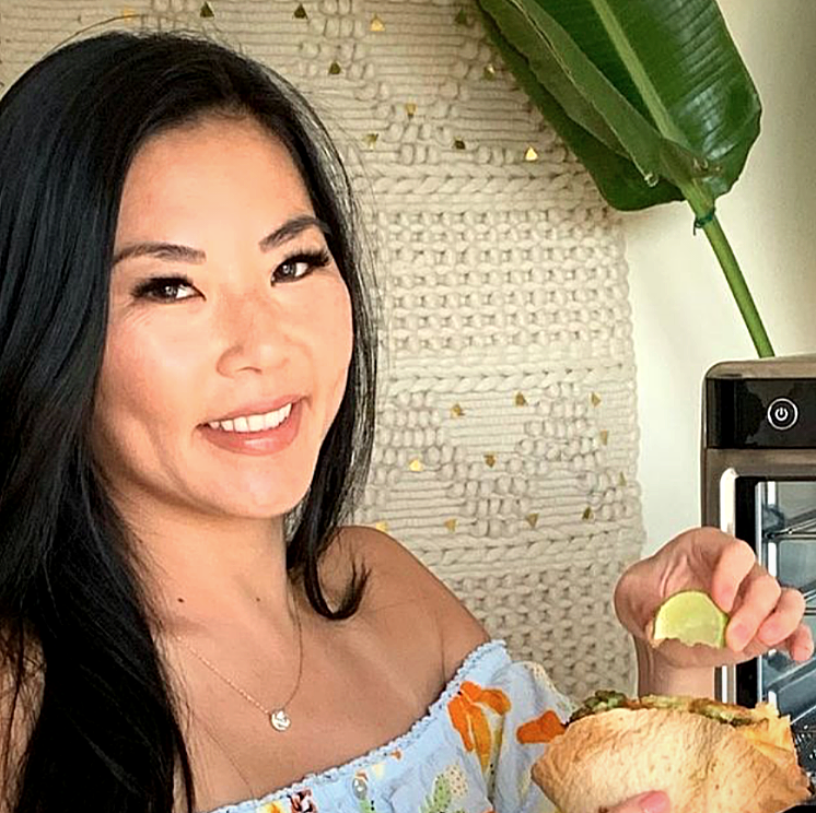 woman holding a slice of lemon