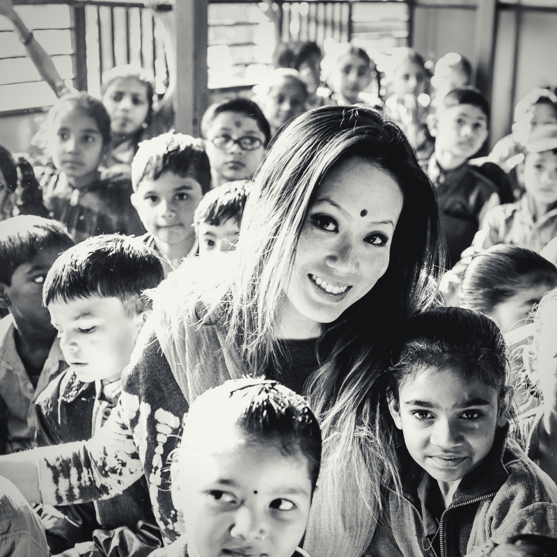 smiling woman surrounded by children