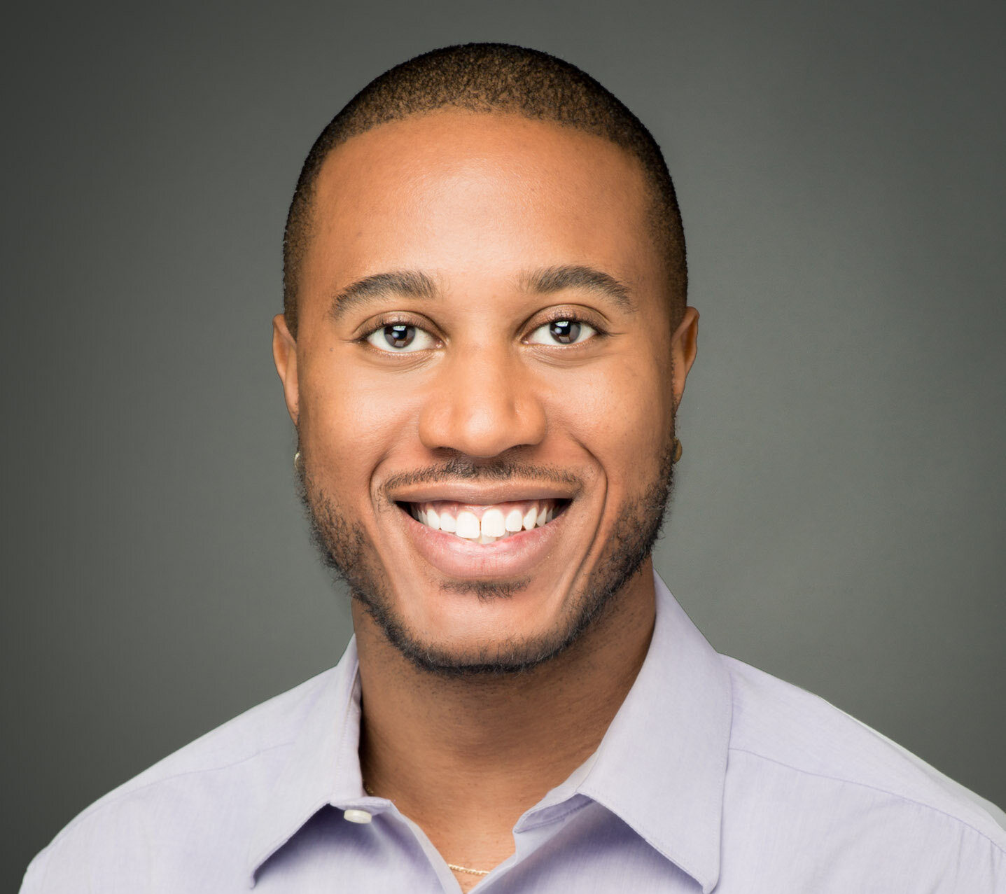 headshot photo of a man smiling