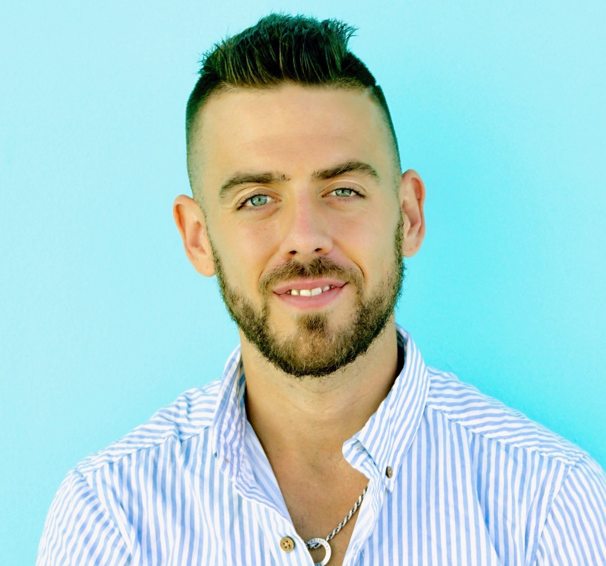 headshot photo of a man in aqua green background