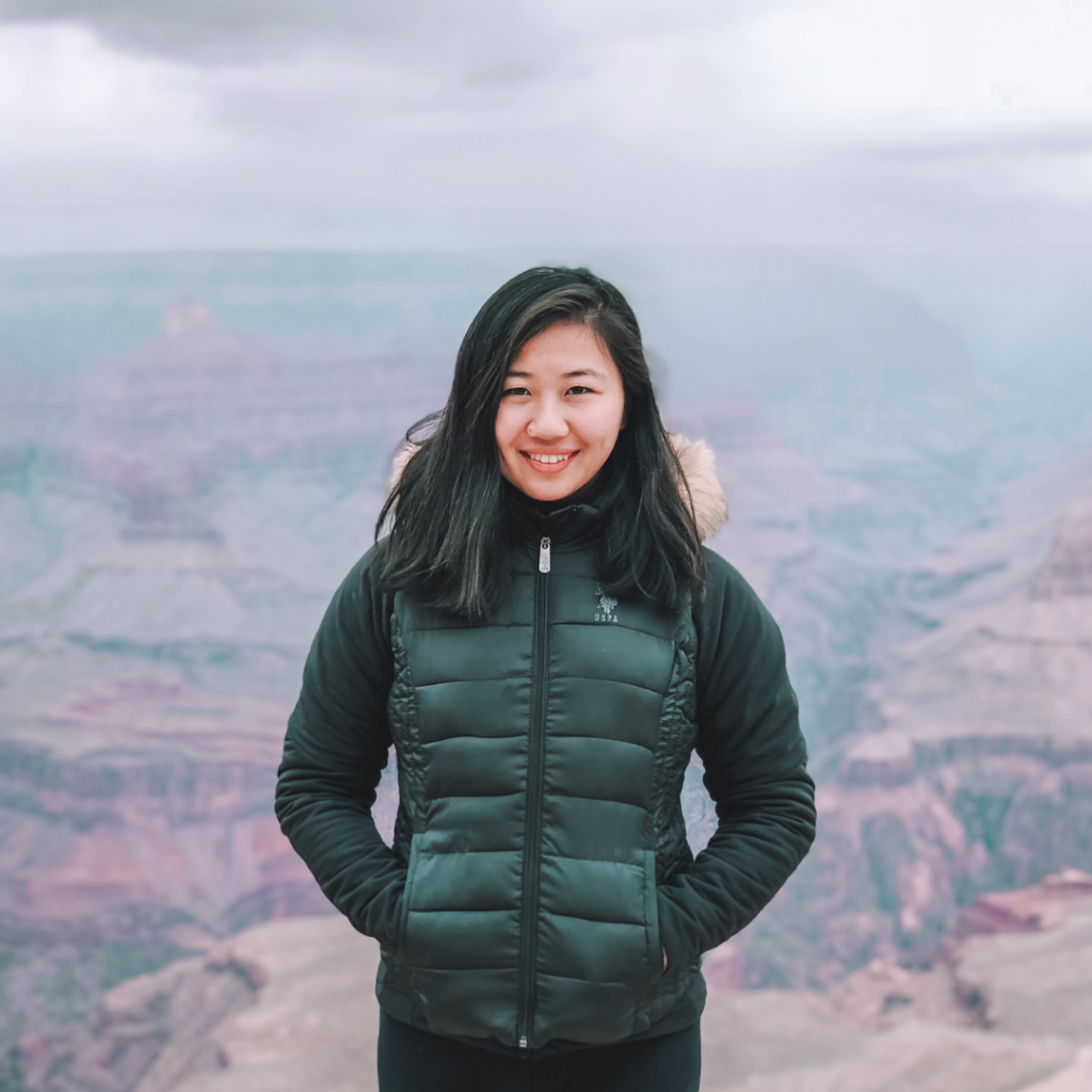 lady posing for a picture on top of a mountain