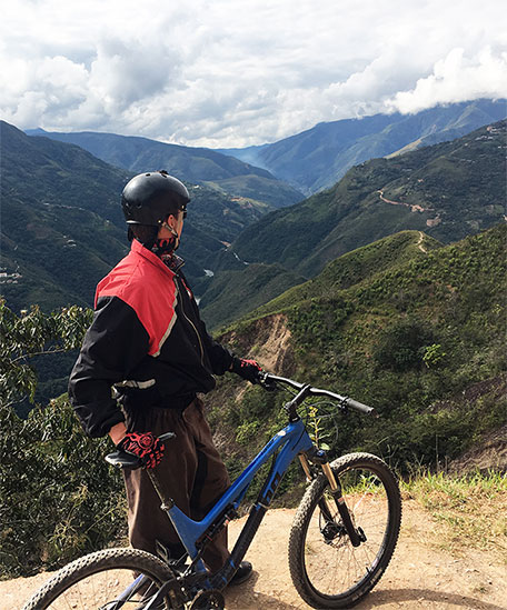 man holding an MTB on top of a hill